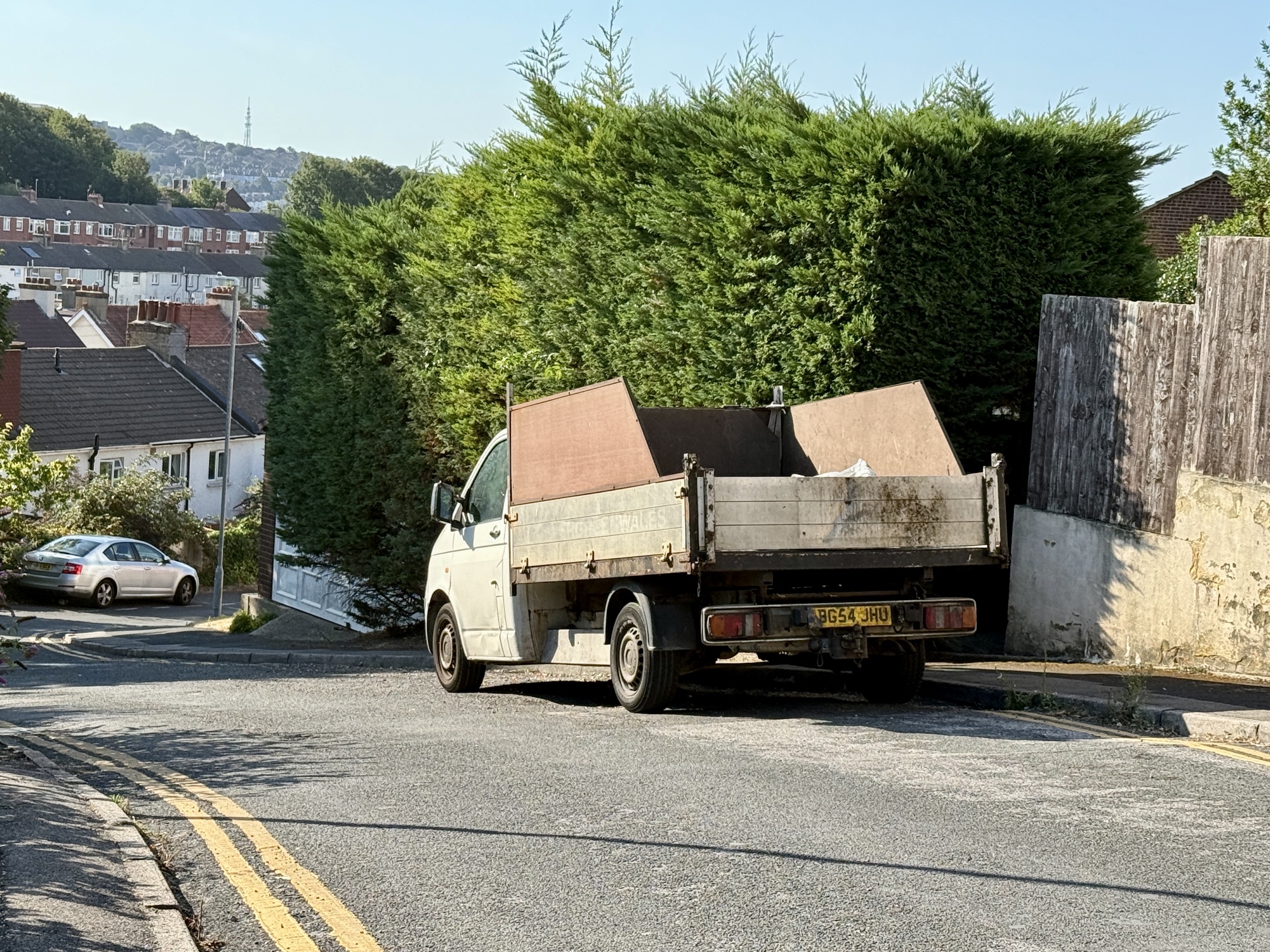 A very large work vehicle, registration BG54 JHU, parked in the unpainted gap on Adams Close, where double yellow lines were intended.